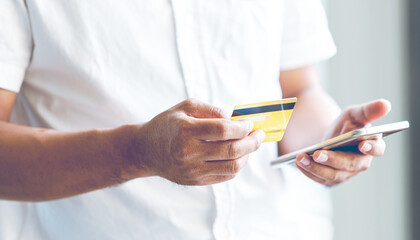 Closeup of a man hand using a smartphone with credit card