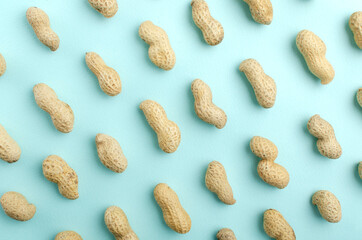 Top view of blue background and raws of peanuts on it