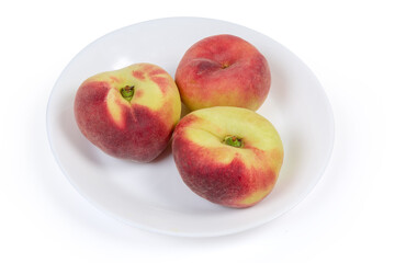 Flat peaches on the white dish on a white background