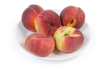 Flat and ordinary peaches on white dish on white background
