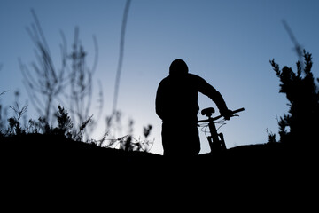 Fototapeta na wymiar Mountain biker silhouetted at sunrise