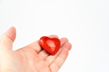 Red heart held in hand, white background and copy space