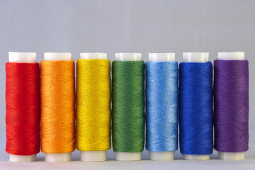 Rainbow colour sewing threads on white background