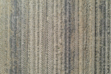 Tractor and combine wheel tracks on a harvested canola ground. Drone photo from above.