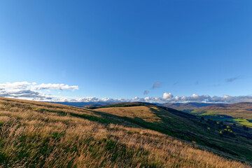 The Rolling slopes of Tulloch hill with the evening light casting long shadows across the Hills and into the Valley below.
