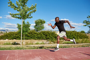 African athlete running on a sunny summer day.