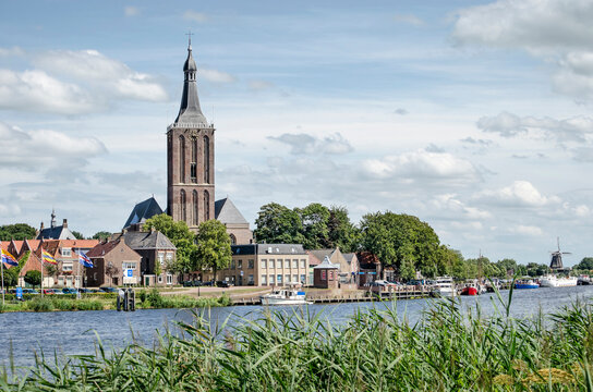Hasselt, The Netherlands, August 2, 2020: view of the town's waterfront, dominated by Saint Staphanus church, with the windmill in the background