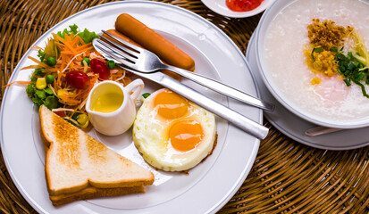 Healthy breakfast with fried eggs,toasts,sausages and fresh salad in white plate.