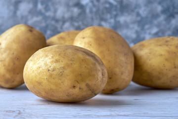 Fresh raw potatoes on textured background