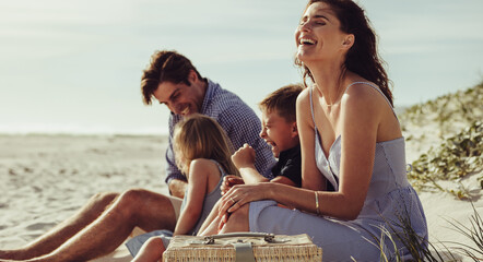 Family sitting on the beach and having fun