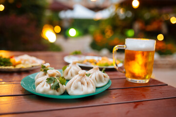 Selective focus on khinkali with mug of cold beer 
