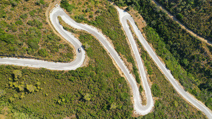Aerial drone top down photo of snake serpentine road leading to mountain top