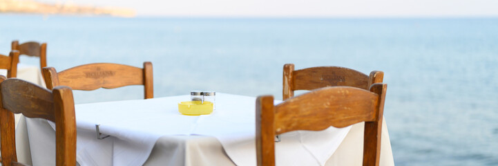 Fototapeta na wymiar cafe tables on the sea mediterranean embankment. selective focus. banner