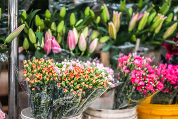 Fototapeta na wymiar Carnations and lilies on the flower's market, flowers for sale, spring flora, decorative bouquet, soft focus, film grain
