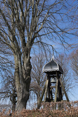 Typical wooden bell tower 'Klokkenstoel' on a cemetery in the village Doniaga in Friesland, the Netherlands