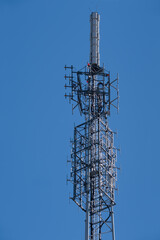 Top of transmission tower for radio and television at blue sky with red warning lights