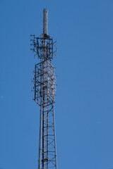 Top of transmission tower for radio and television at blue sky with red warning lights