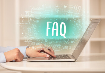 hand working on new modern computer with FAQ abbreviation, modern technology concept