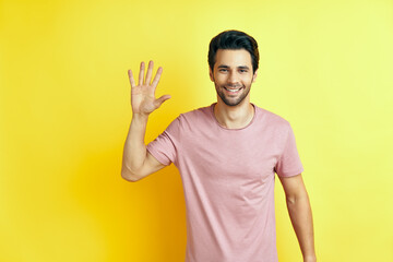 Portrait of smiling man with hand raised in greeting