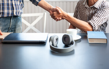 Two young men held hands in greeting and getting to know each other.