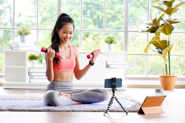 Exercise online training class at home, Asian girl holding dumbbell for workout fitness, Healthy asia woman training  exercise by mobile phone, Female sport blogger recording video by smartphone