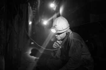 Silhouette of a working miner in a mine