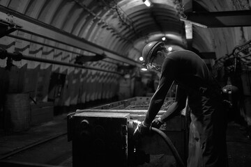 Silhouette of a working miner in a mine