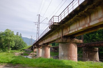 Fototapeta na wymiar Concrete river bridge. Reinforced concrete bridge construction. Mountain bridge nature background.