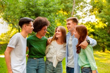 University Friendship. Multiracial students standing together at campus, embracing and laughing