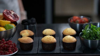Confectioner making muffins. Modern desserts and cakes. Cupcakes with cream filling. Professional pastry.