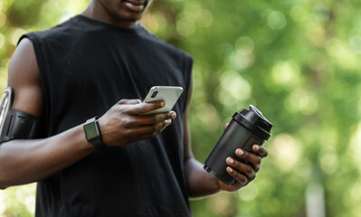 Cropped of african sportsman checking on sport app during break