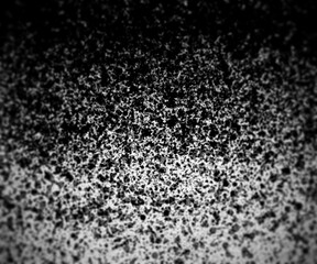 Dirty black dots texture with circular blur. Dark gradient background with selective focus.