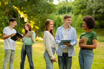 University students resting outdoors at campus after classes, chatting and smiling