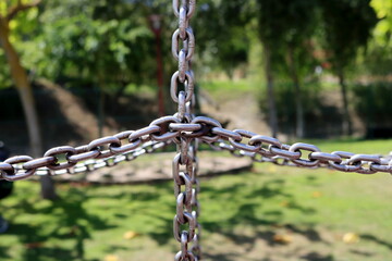 Crossed metal chain on blur green nature - background concept