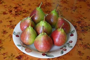 Fresh pears on ceramic plate on kitchen table. Organic ripe pear. Concept of natural healthy food. Selective focus.