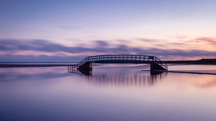 The Belhaven Bridge, Dunbar, before dawn. Also known as the Bridge to Nowhere, as although it crosses the River Biel, its base is submerged at high tide. - obrazy, fototapety, plakaty