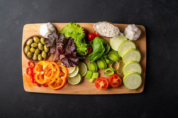 Background healthy food - raw tomatoes, peppers, olives, garlic on a black background, bright color, vitamin food with copy space