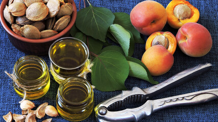 Apricot kernel oil in a jar. Apricots, seeds and apricot leaves.