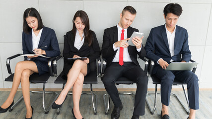 Group of diverse business man and woman sitting in office waiting for job interview.