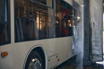 Close up of white bus being in car wash