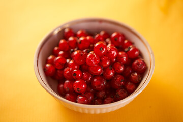 Red currants on a yellow background. Close-up.