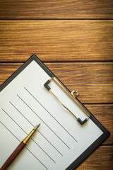 Paper sheet with empty to do list and a pen on vintage wooden table