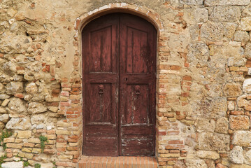 Fototapeta na wymiar Ancient door of a house in the medieval center of San Gimignano