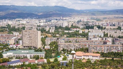 Fototapeta na wymiar Panoramic view of Zghvisubani District with its Soviet looking buildings located at the outskirts of Tbilisi. The view is taken from Chronicles of Georgia monument. 