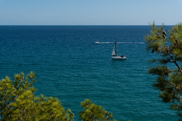 View of the beautiful blue Mediterranean sea with rocks near the shore with waves on a sunny day...
