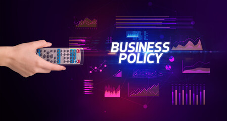 hand holding wireless peripheral with BUSINESS POLICY inscription, cyber business concept