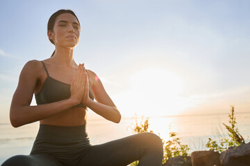 Charming young woman meditating on sunny day