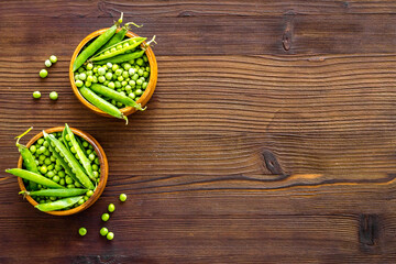 Bowl of green pea pod with beans on kitchen desk. Top view