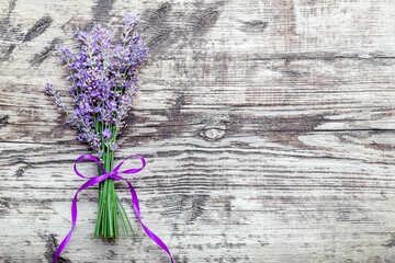 Fresh lavender flowers bouquet on old rustic wooden table. Flatlay purple herbal flower blossom. Bouquet of lavender tied with ribbon with copy space for text. Lavender aromatherapy.