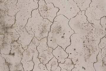 Сracks on a beige wall.